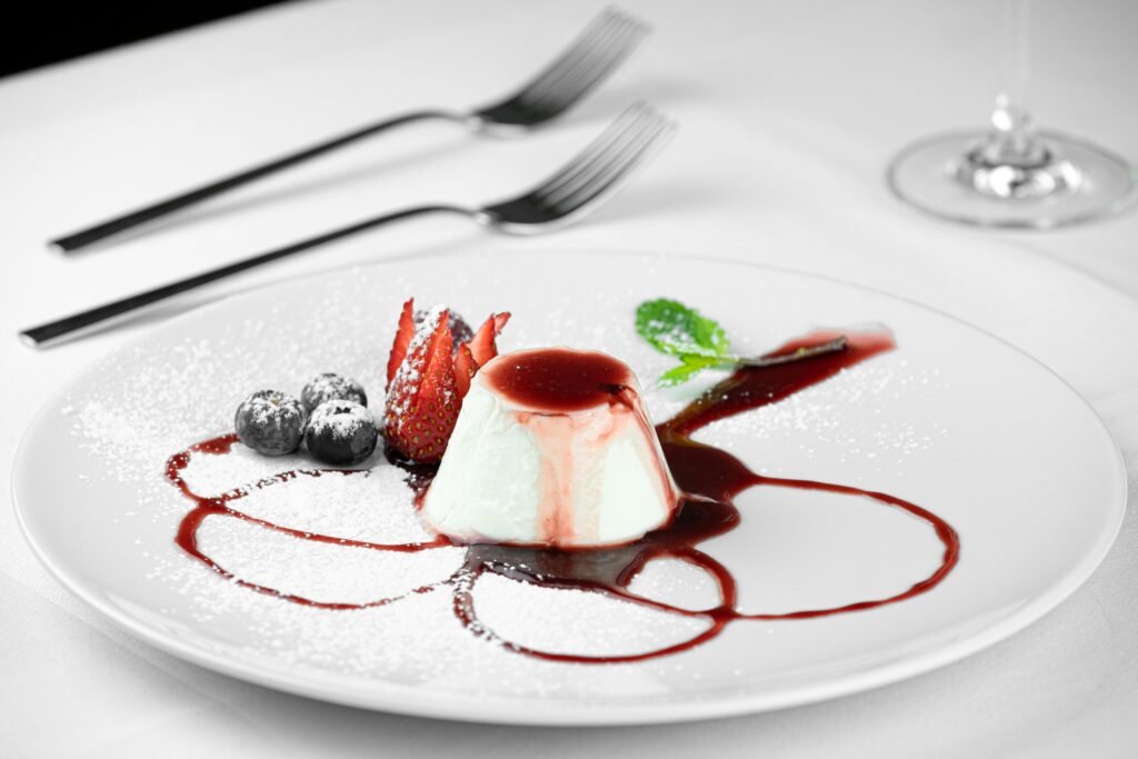 Delicious panna cotta dessert with fresh berries and mint, elegantly plated.