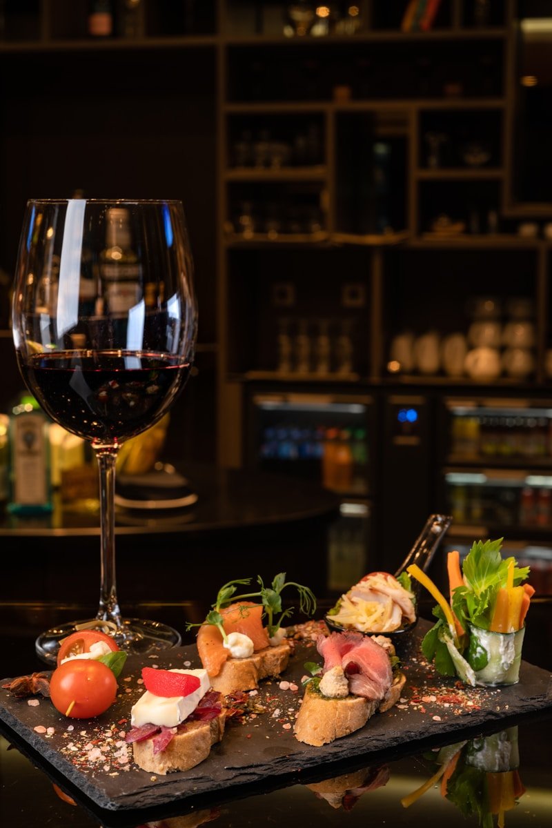 a glass of wine sitting next to a plate of food